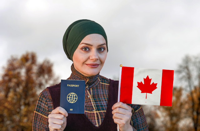 woman holding passport and small Canadian flag